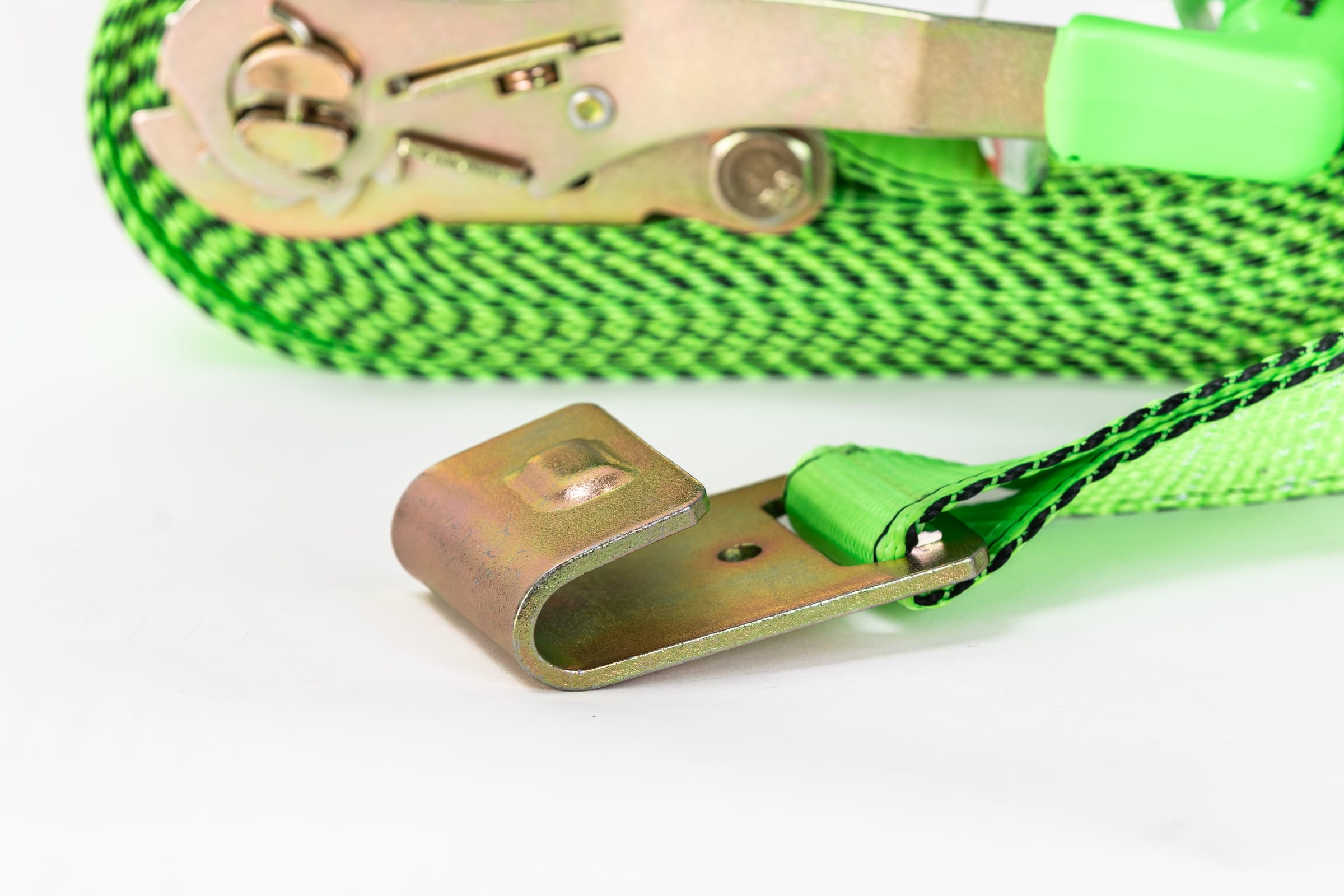 Close product photograph of a green ratchet strap and its brass hook on a clean white ground.
