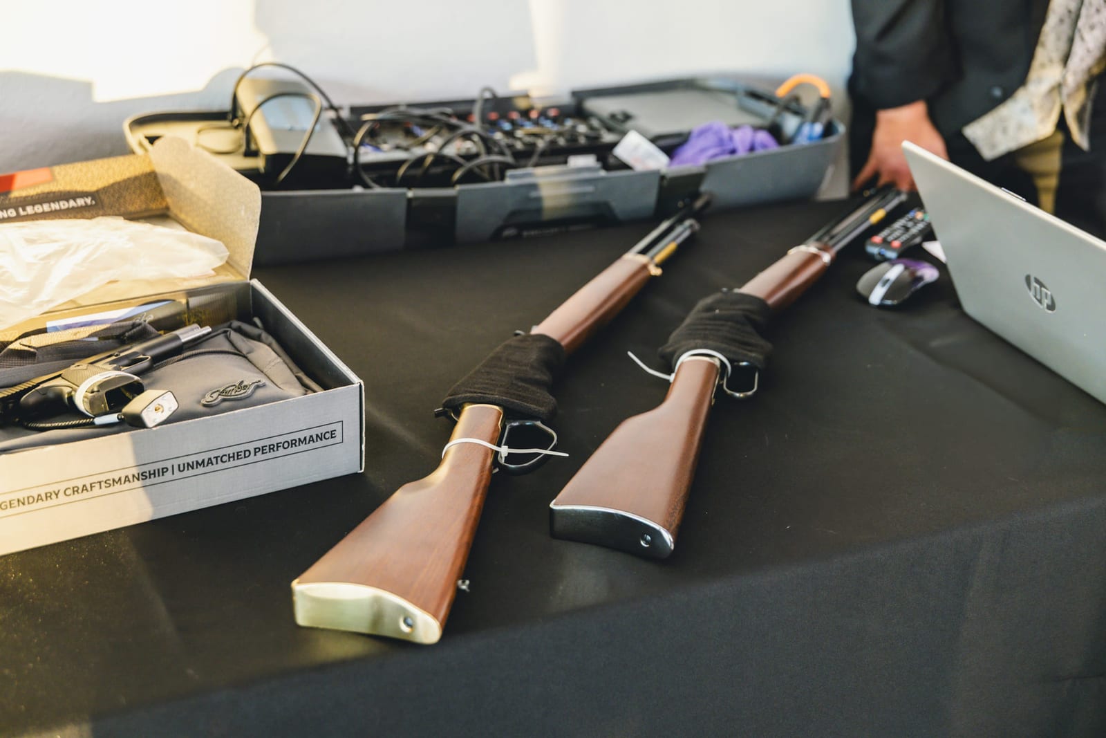 Styling tools laid out on a dark table, their cases open behind.