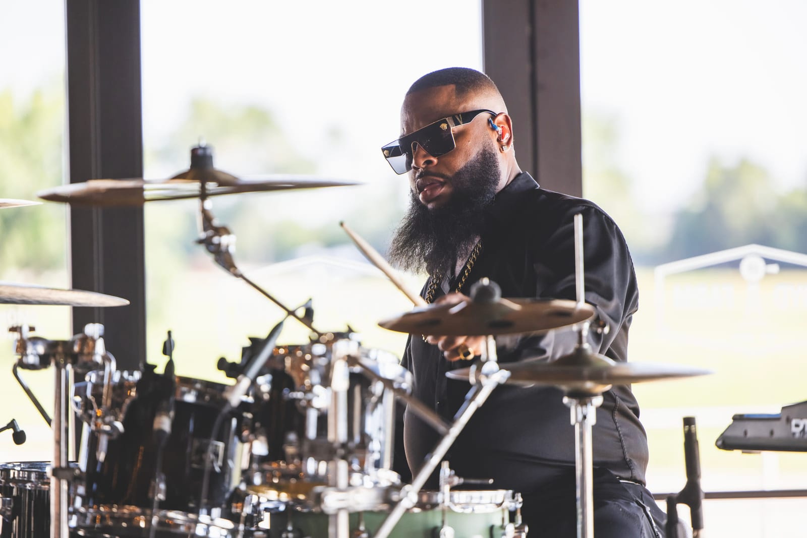 A drummer behind a kit on stage, cymbals catching the light.