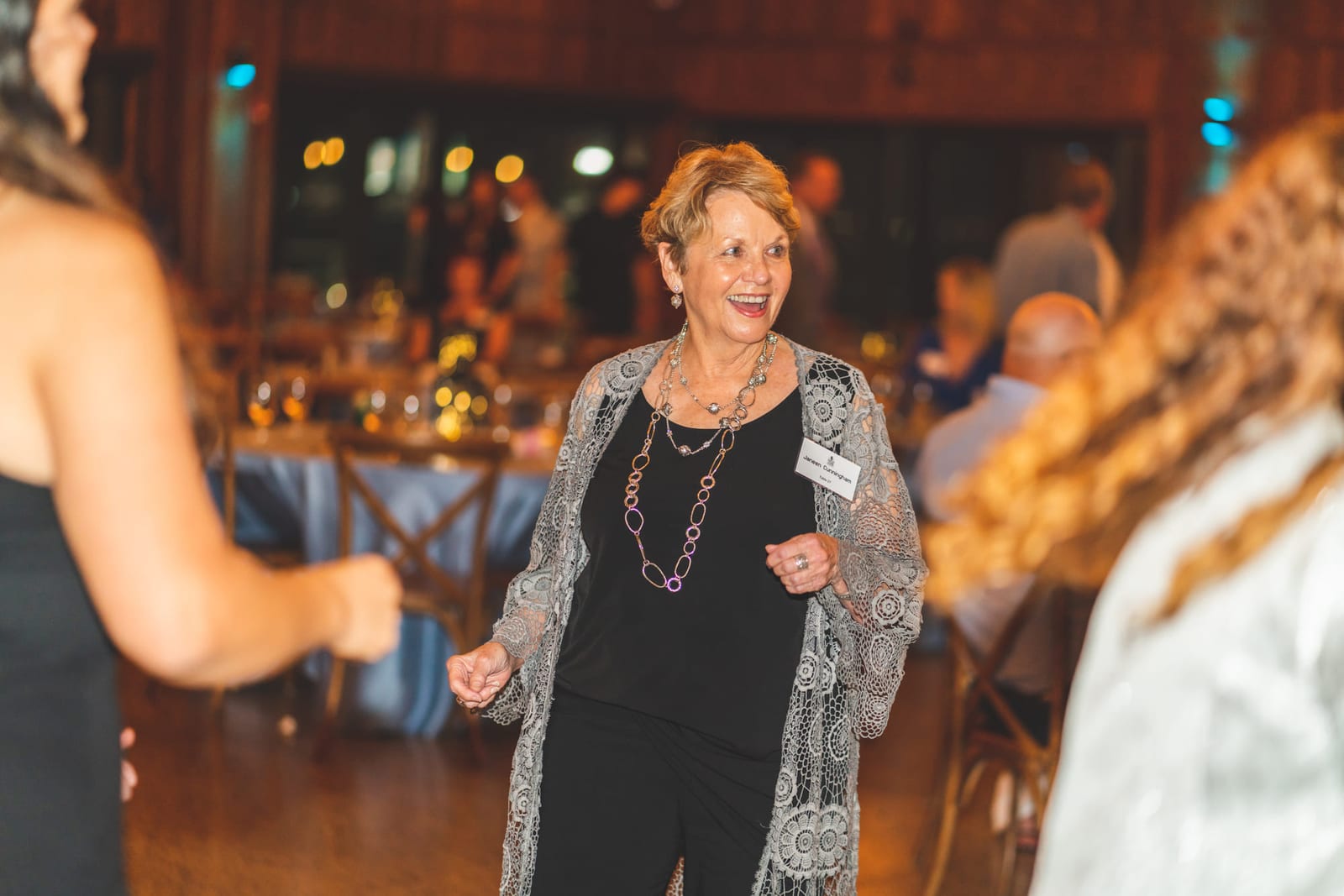Guests dancing at a gala, one turning toward the camera mid-step.